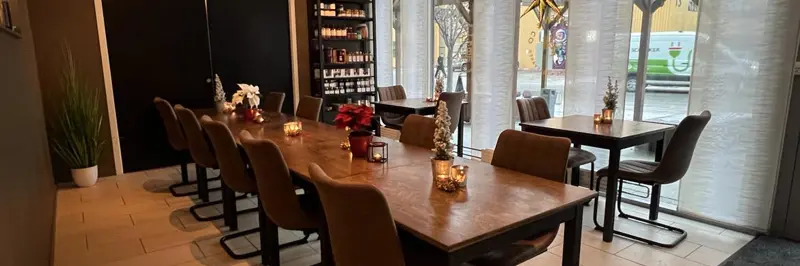 Langbord dekket til middagsselskap med levende lys og vin.