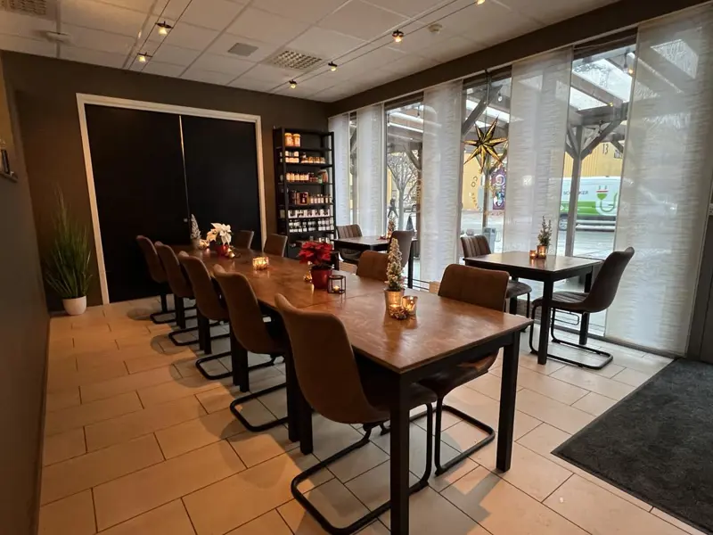 Langbord dekket til middagsselskap med levende lys og vin.